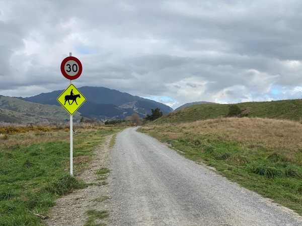 A gravel road in QEP with a speed limit 30 sign