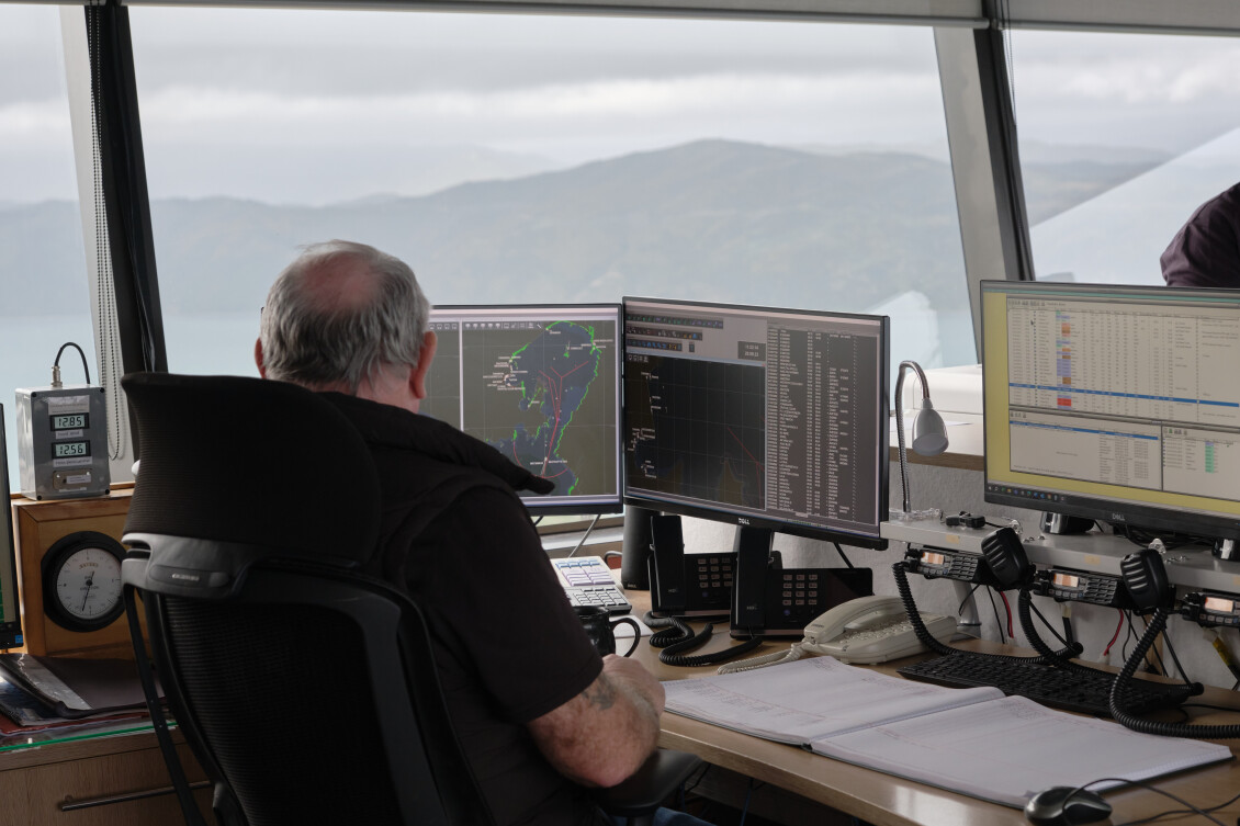 A Harbours staff member at a desk, monitoring harbour data on a computer