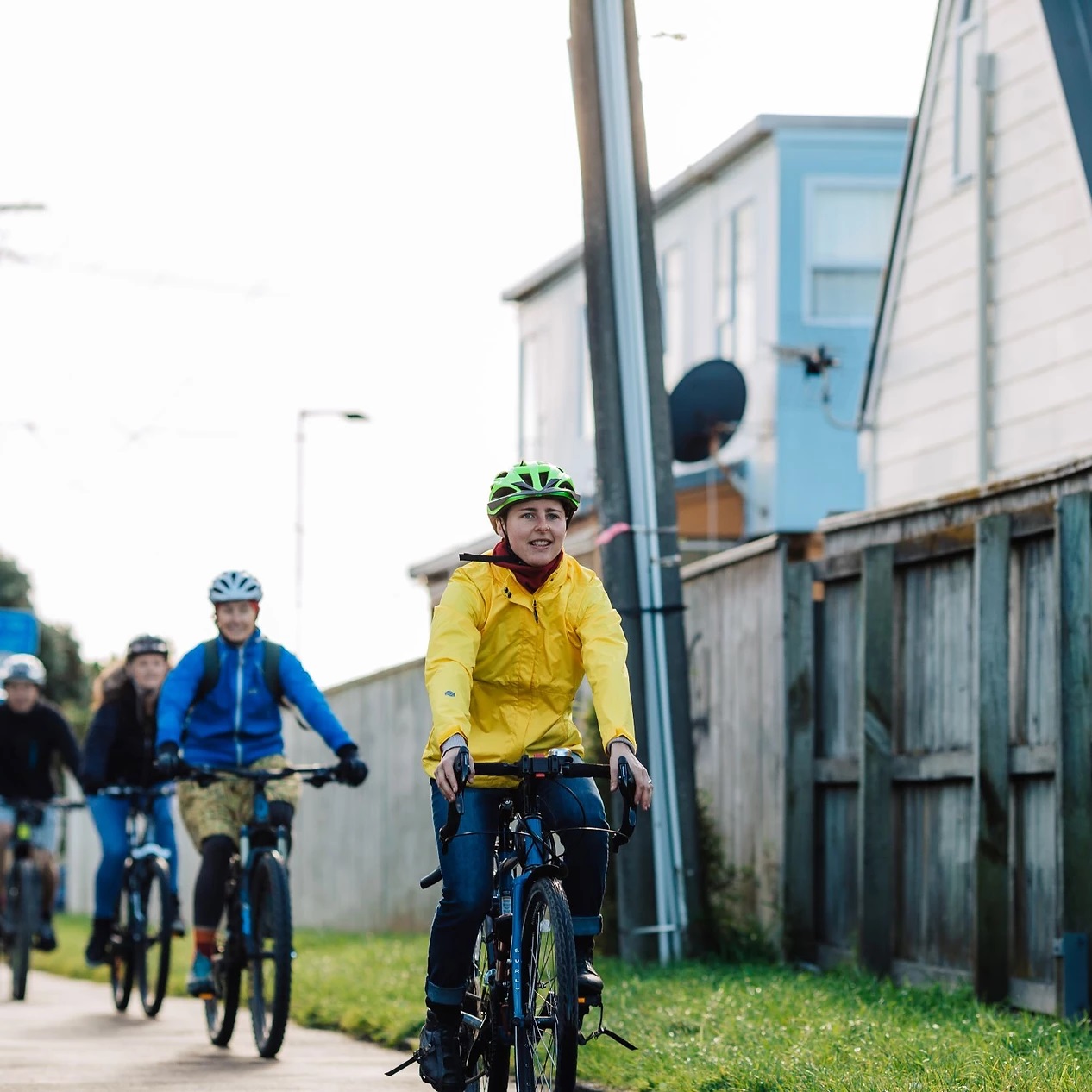 A row of cyclists biking down a path