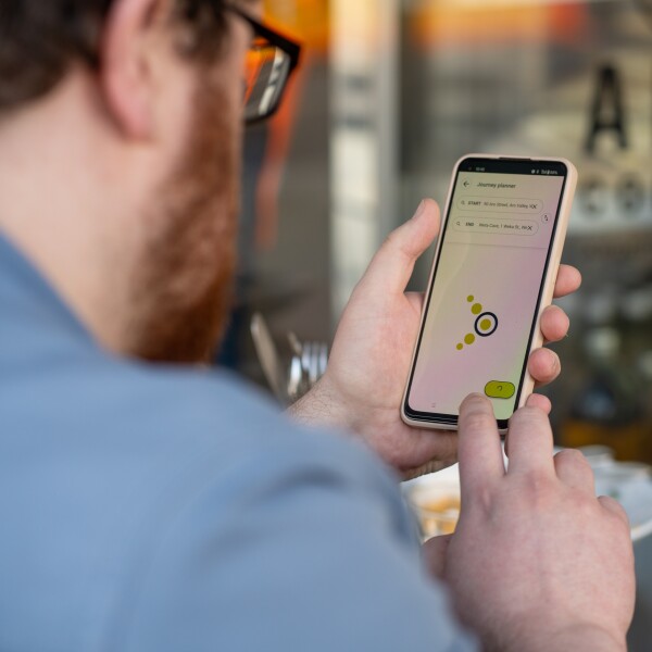 A man looking at the Metlink Journey Planner on his phone