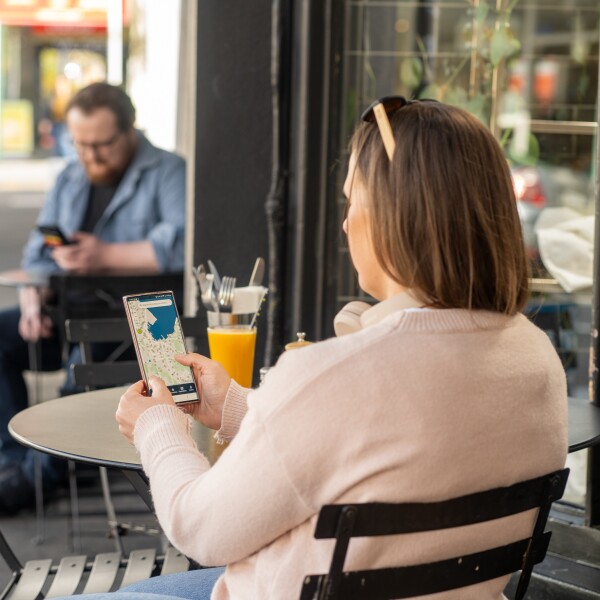 A woman looking at the Metlink Journey Planner on her phone