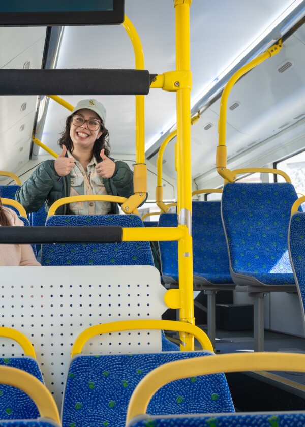 A person on a bus giving two thumbs up