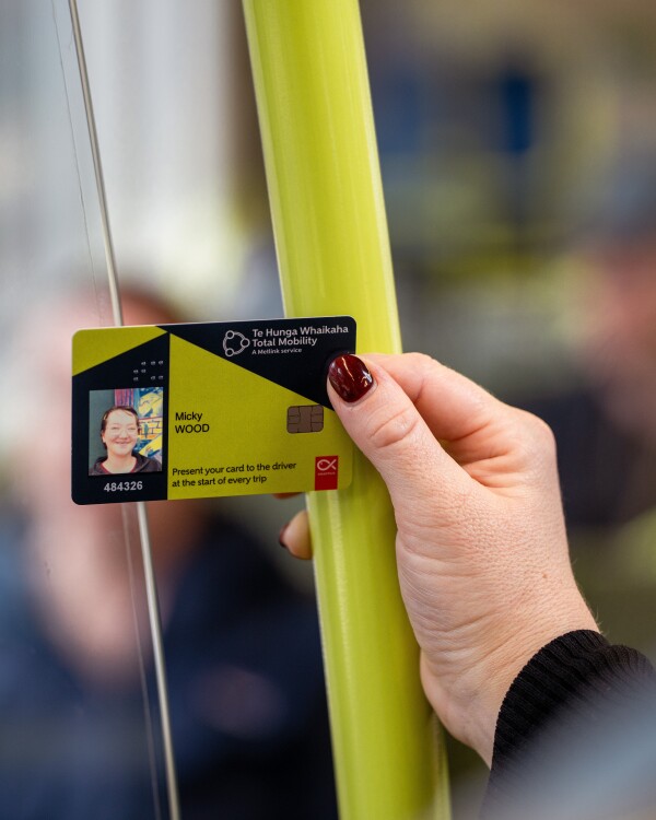 A hand holding a Total Mobility card