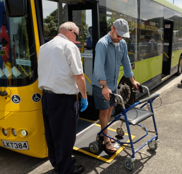 A person with a walker exiting the bus using the ramp