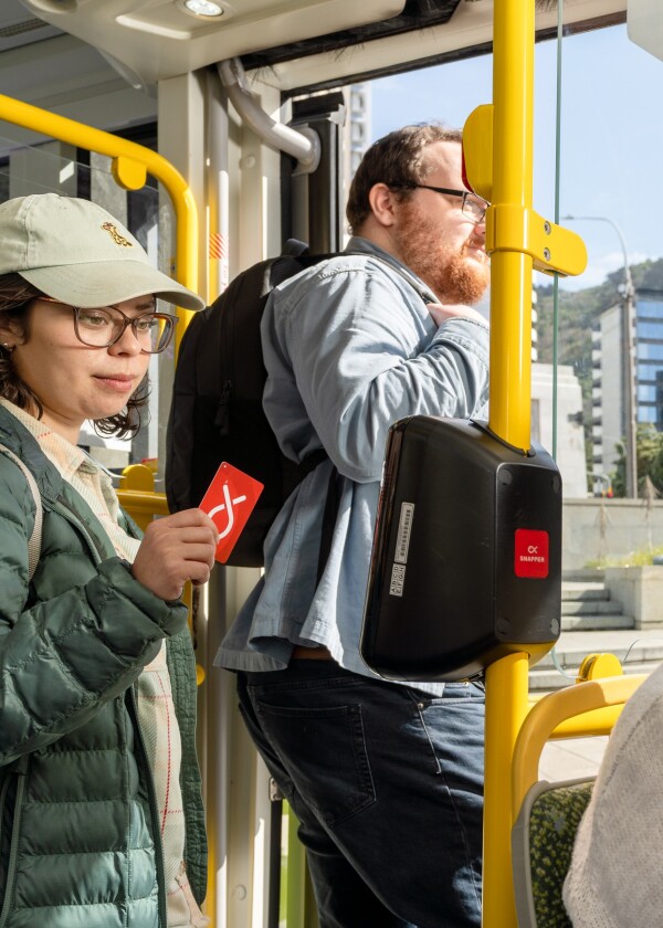A person holding their Snapper card to the reader as they exit the bus