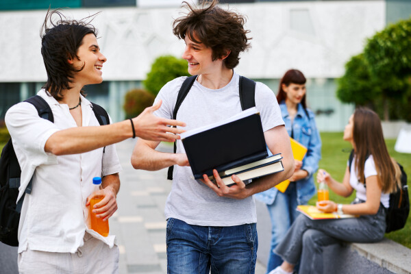 Two young adults talk to each other as they walk down a street