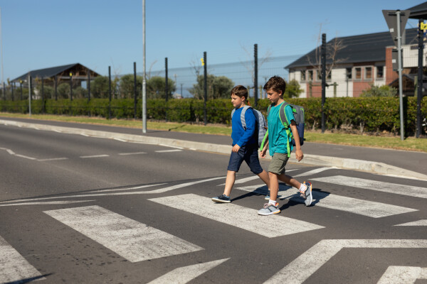 Two children cross the road at a zebra crossing
