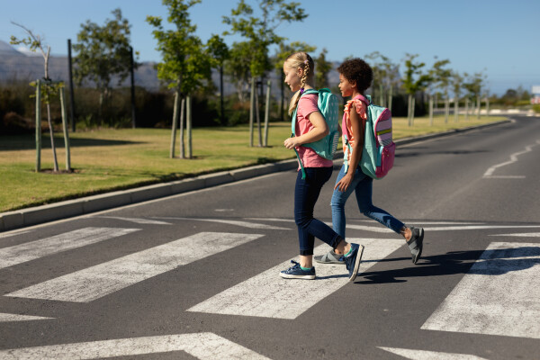 Two children cross the road at a zebra crossing