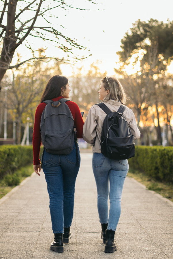 Two women walk down a footpath