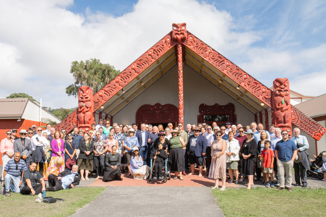 Group of people stand in front of Takapūwāhia Marae after the signing of the Porirua Harbour Accord.