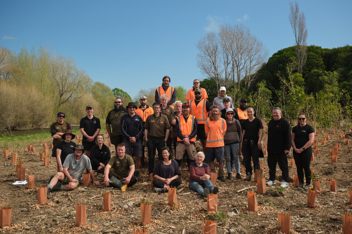 A group of volunteers pose among newly planted seedlings at Edgewater Park Planting Day