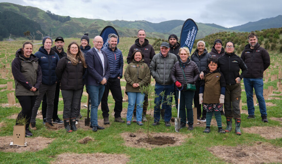 Chair Daran Ponter, Park ranger Jordan Clear, Greater Wellington staff, mana whenua and community members pose with the millionth native tree planted in regional parks